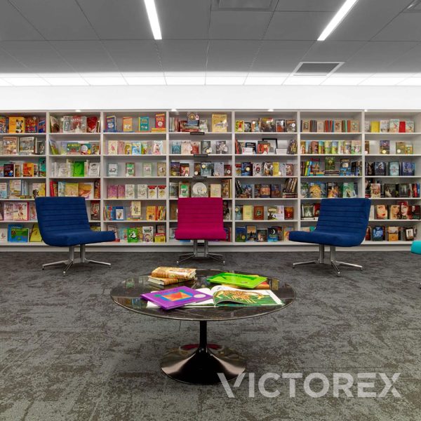Interface Net Effect B603 carpet tile in area with bookshelves and colorful chairs in Black Sea colour
