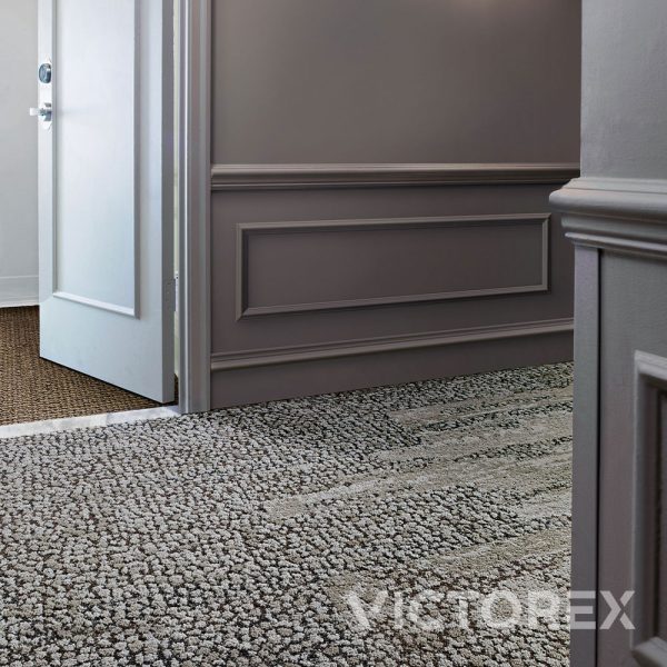 Interface Human Nature HN840 plank carpet tiles in Nickel, in hotel hallway with hotel room door ajar; HN850, Nickel, Ashlar layout.