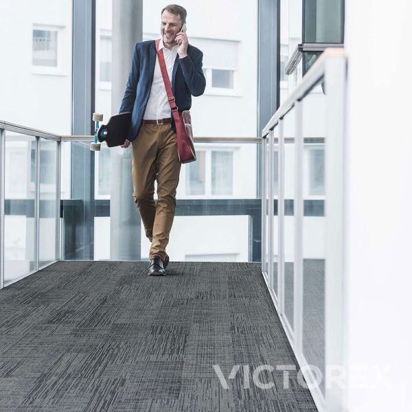 Interface Works Unite carpet tile in Flint, with a man in office area; Ashlar layout