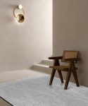 Victorex Luca Rugs on wooden bench in living room beside stairs with wall golden ring light.