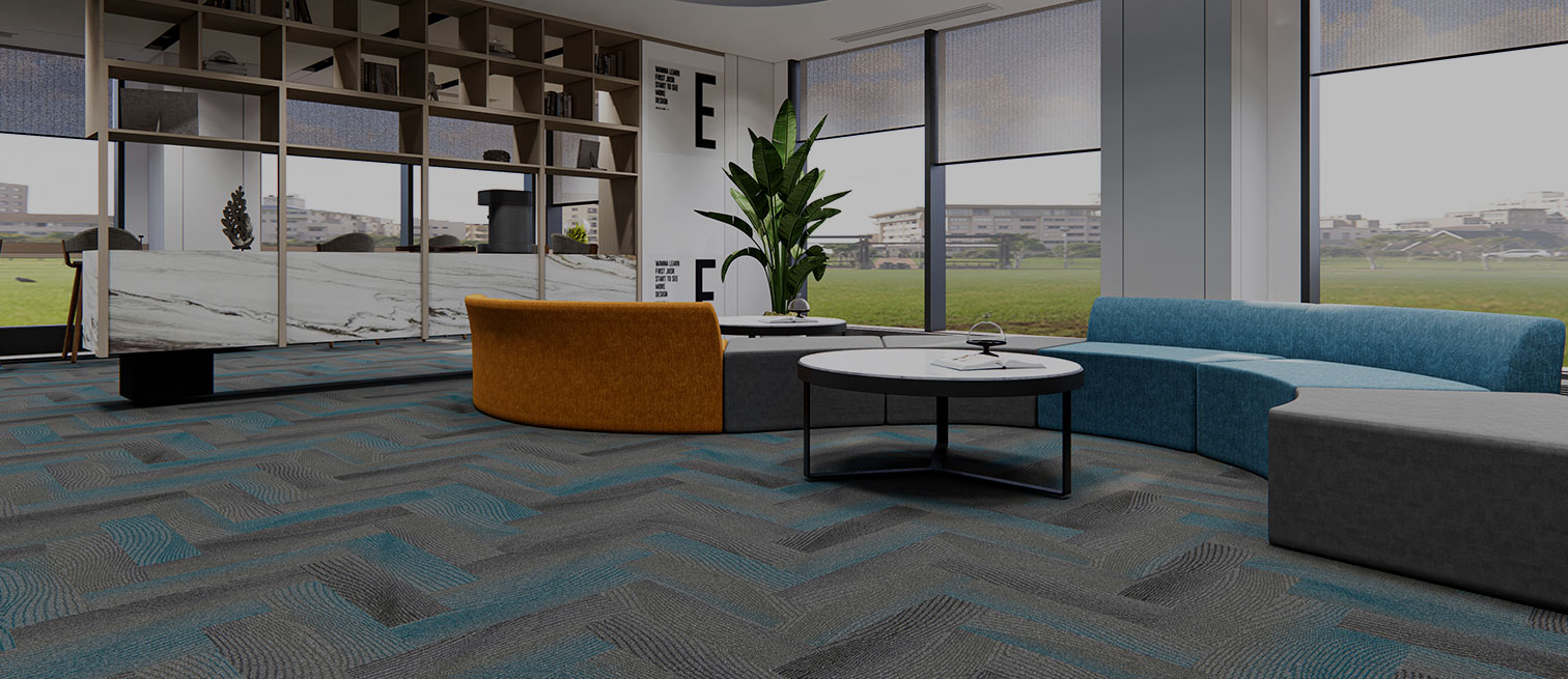 Victorex Layers Carpet Tiles flooring in Mist and Marine Mist colour combination, installed in Herringbone method in a lobby sitting area with curved sofa.